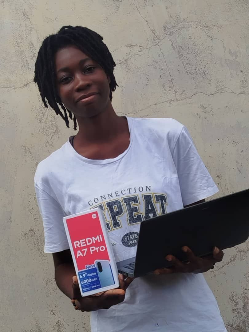 Dush Tech learner with laptop and new phone earned through digital work