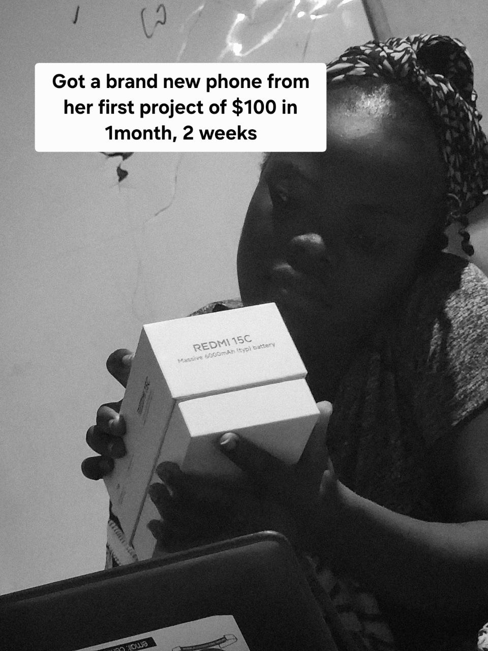 Learner holding a Redmi phone box earned from her first $100 project