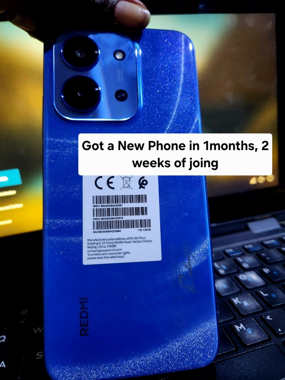 New Redmi phone resting on a laptop keyboard